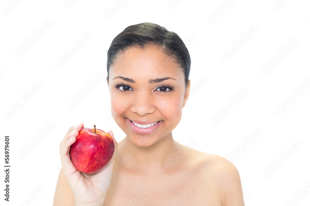 Delighted young dark haired model holding a red apple Delighted young dark haired model holding a red apple