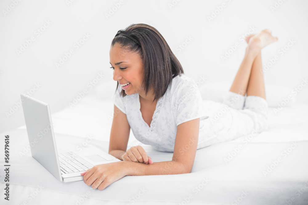 Delighted young dark haired model using a laptop Delighted young dark haired model using a laptop