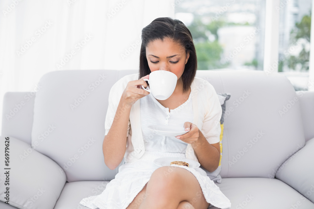 Relaxed young dark haired woman in white clothes enjoying coffee Relaxed young dark haired woman in white clothes enjoying coffee