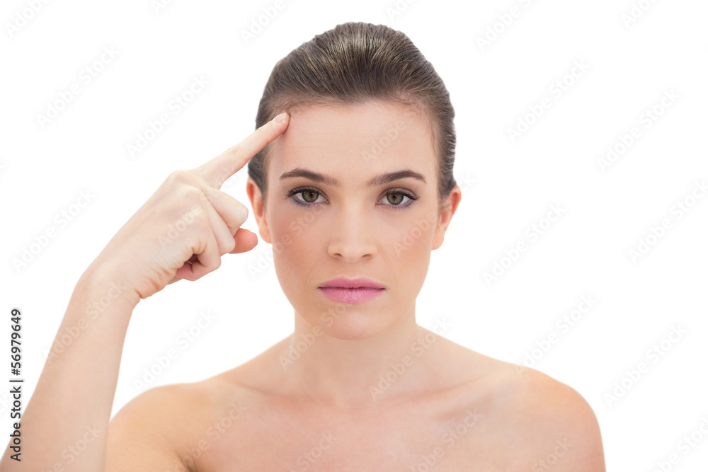Stern natural brown haired model touching her brow Stern natural brown haired model touching her brow