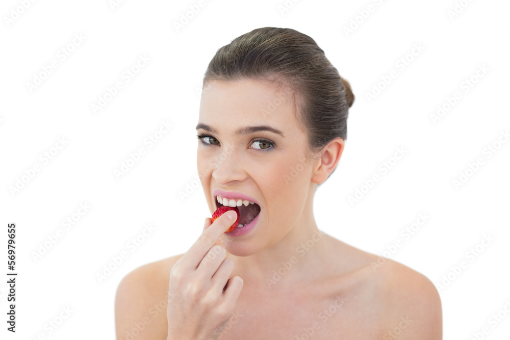 Attractive natural brown haired model eating a strawberry Attractive natural brown haired model eating a strawberry