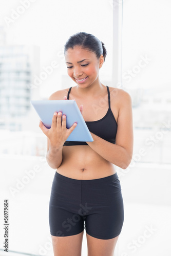 Lovely dark haired model in sportswear using a tablet pc Free Download Lovely dark haired model in sportswear using a tablet pc - GFXLoad