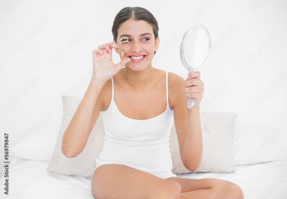 Pretty young brown haired model in white pajamas curling her eye Pretty young brown haired model in white pajamas curling her eye