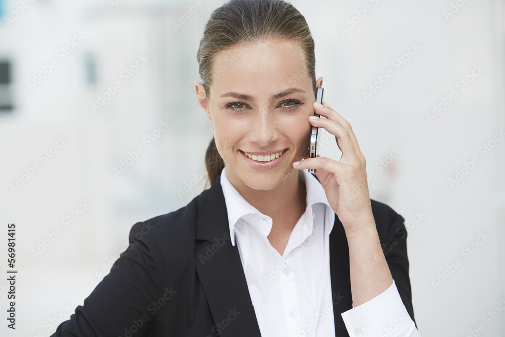 Young businesswoman using cellphone, smiling Young businesswoman using cellphone, smiling