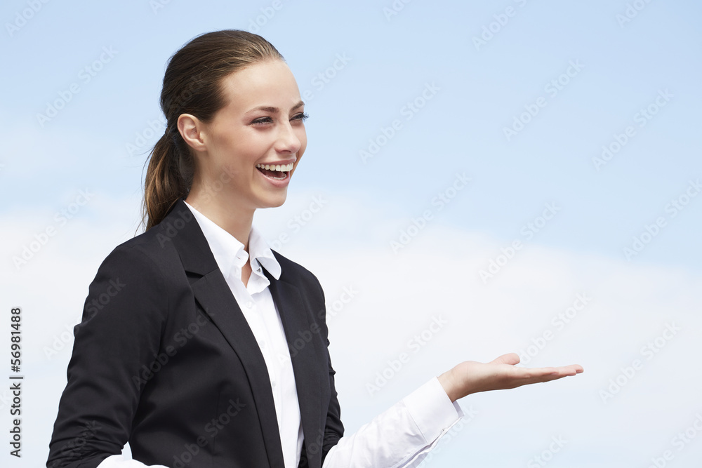 Young businesswoman looking away against blue sky Young businesswoman looking away against blue sky