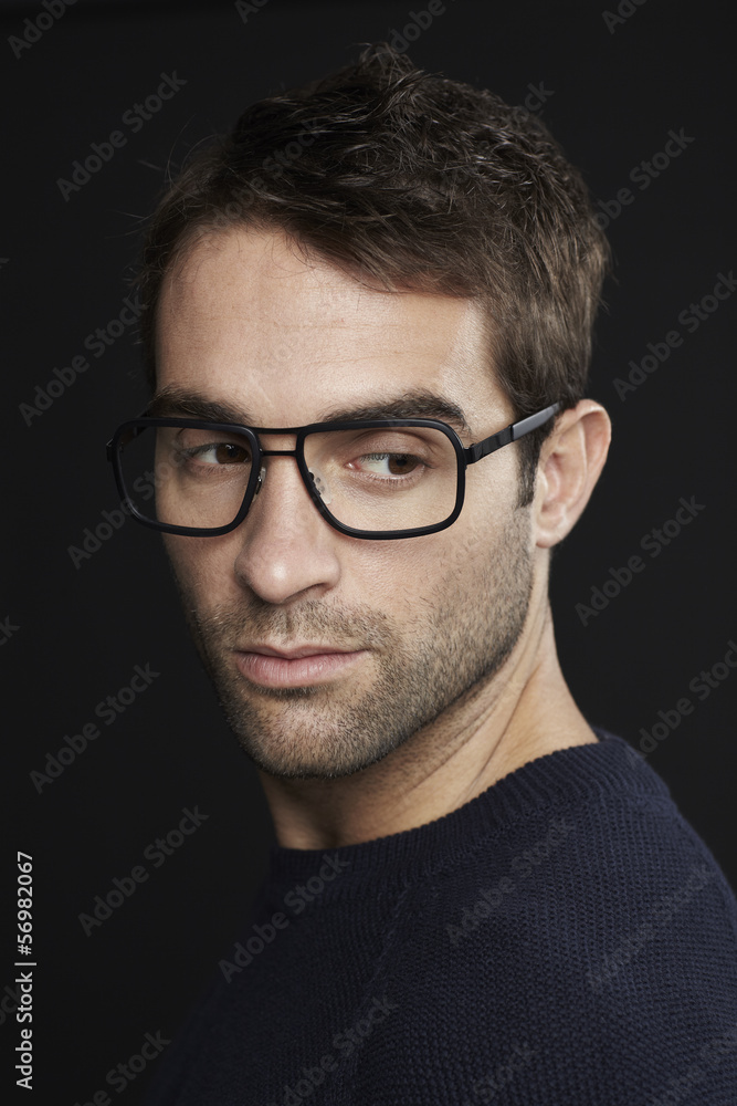 Mid adult man with glasses looking over shoulder Mid adult man with glasses looking over shoulder
