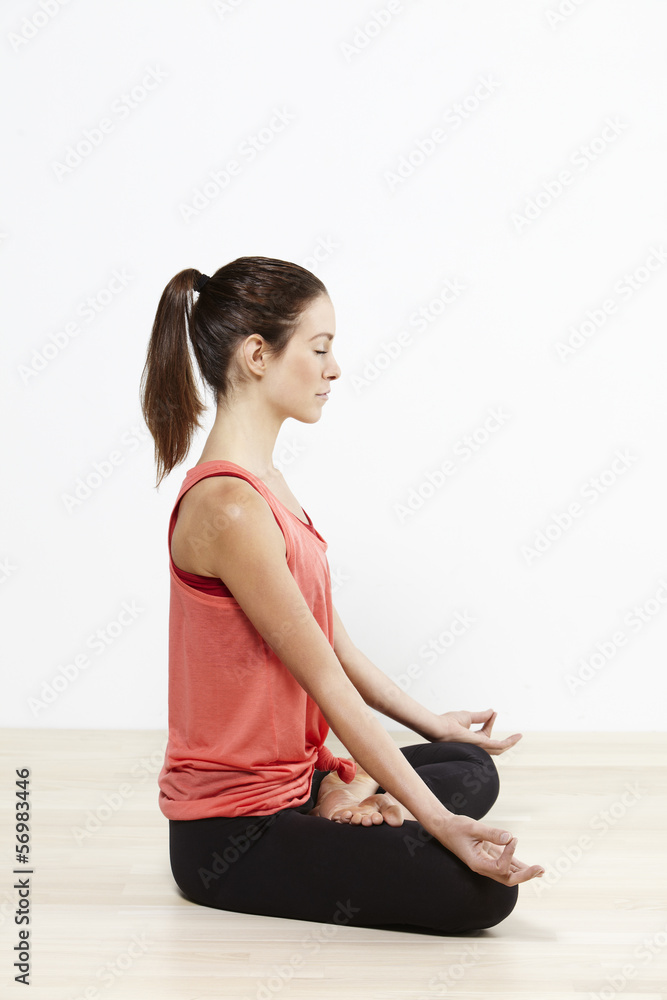 Fototapeta premium Young active woman doing yoga. The lotus position