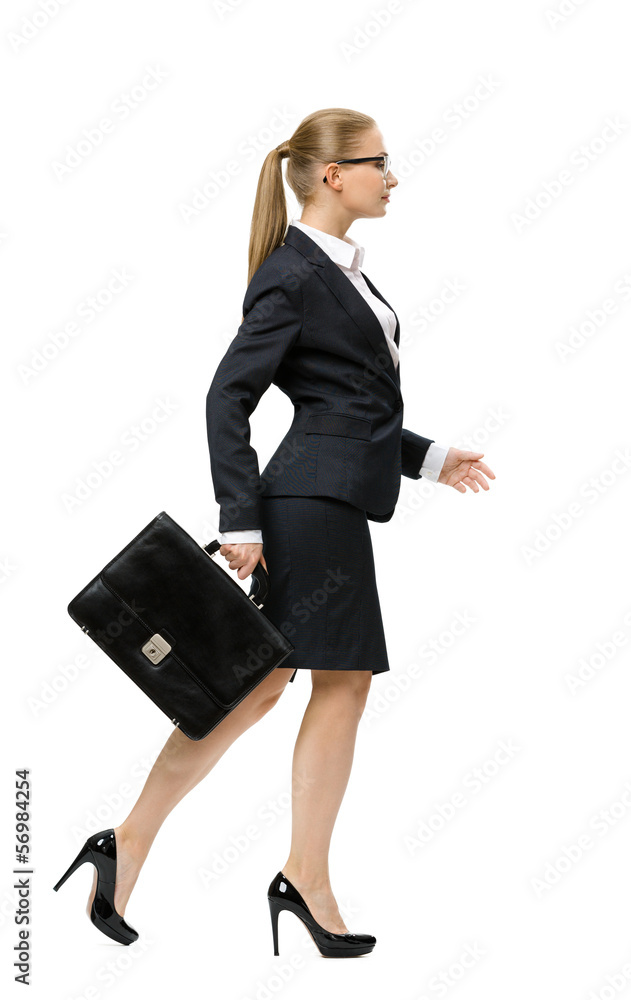 Profile of walking businesswoman handing case Profile of walking businesswoman handing case