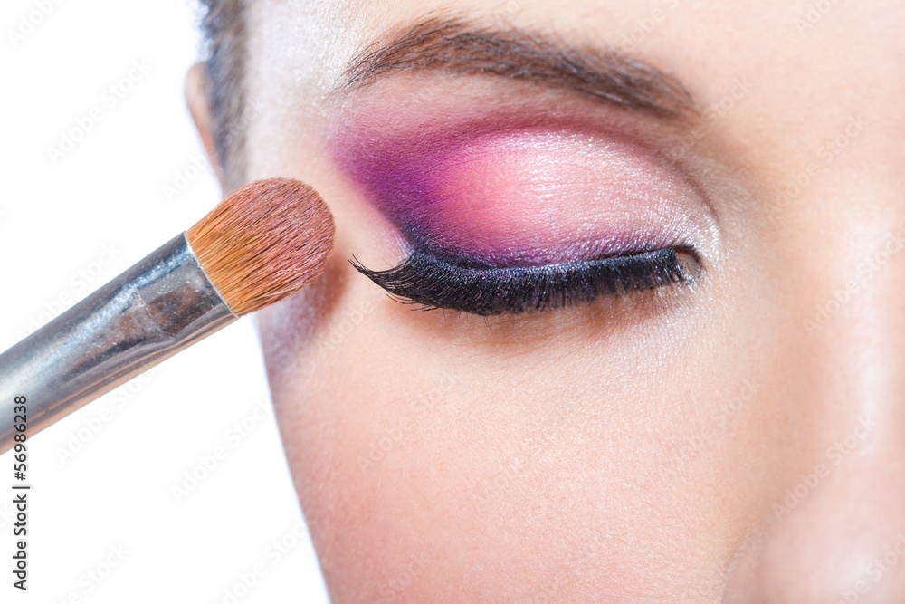 Obraz premium Close up of brush applying bright pink makeup