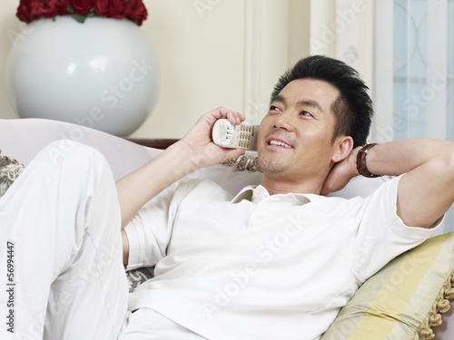 Canvas Print asian man talking on phone at home
