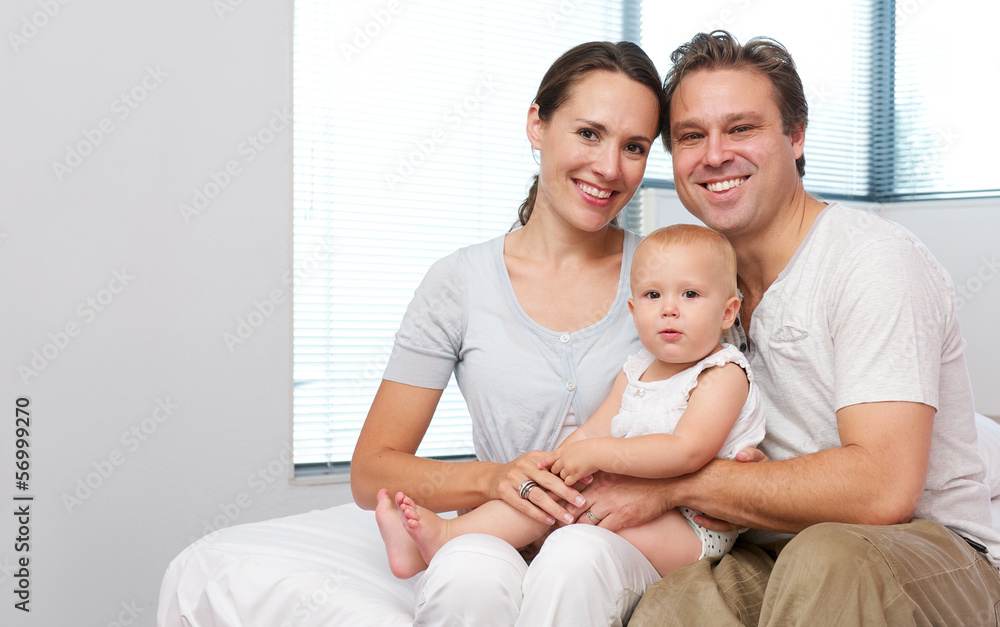 Happy mother and father sitting at home with cute baby Happy mother and father sitting at home with cute baby
