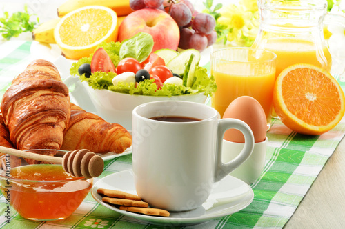 Breakfast with coffee, orange juice, croissant, egg, vegetables