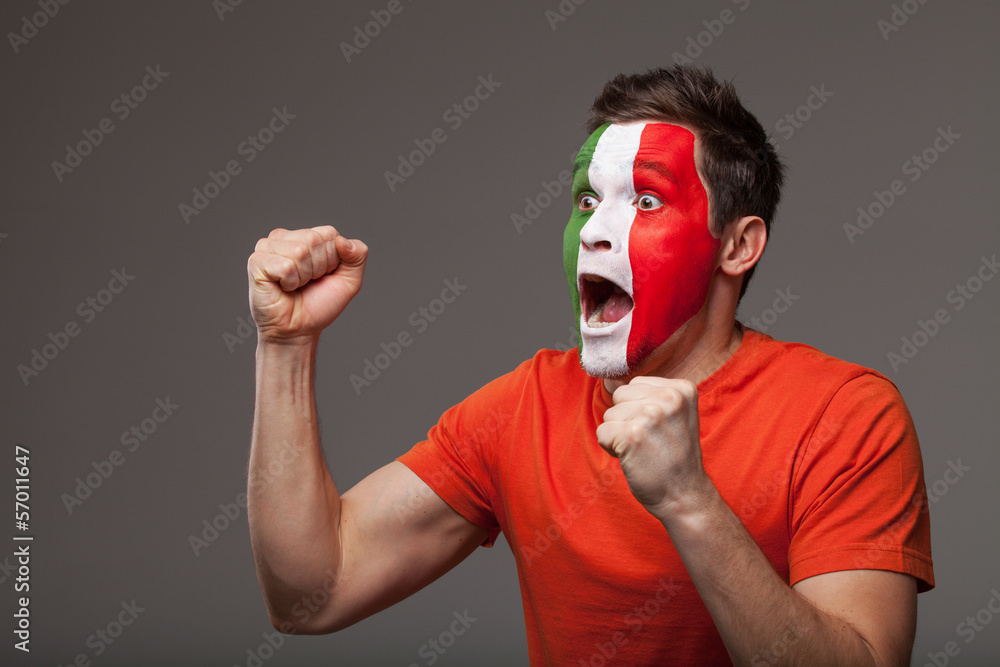 Footbal fan is rooting. With painted Italian flag on a face Footbal fan is rooting. With painted Italian flag on a face