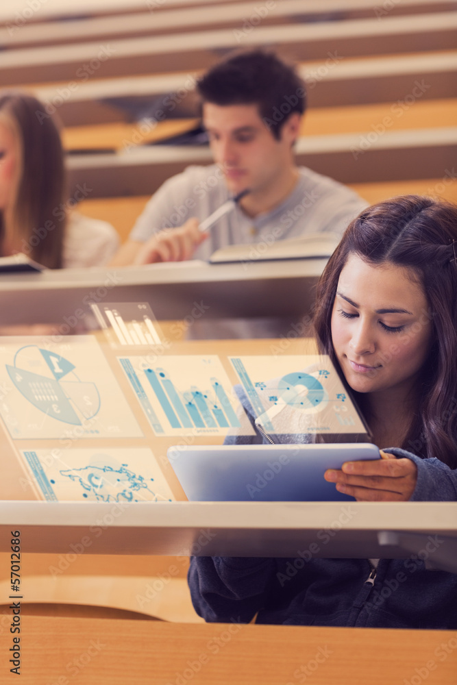 Pretty student analysing graphs on her digital tablet computer Pretty student analysing graphs on her digital tablet computer