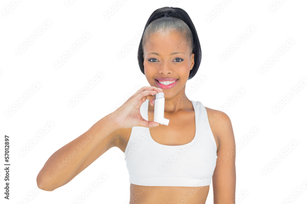 Smiling woman holding asthma inhaler while looking at camera Smiling woman holding asthma inhaler while looking at camera
