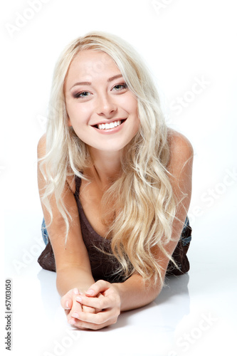 Beautiful blond young woman lying and looking at camera. Isolate photo