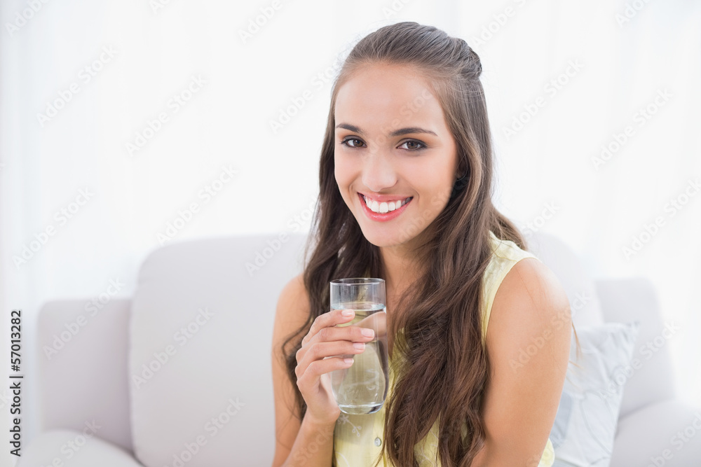 Smiling young brunette holding glass of water Smiling young brunette holding glass of water