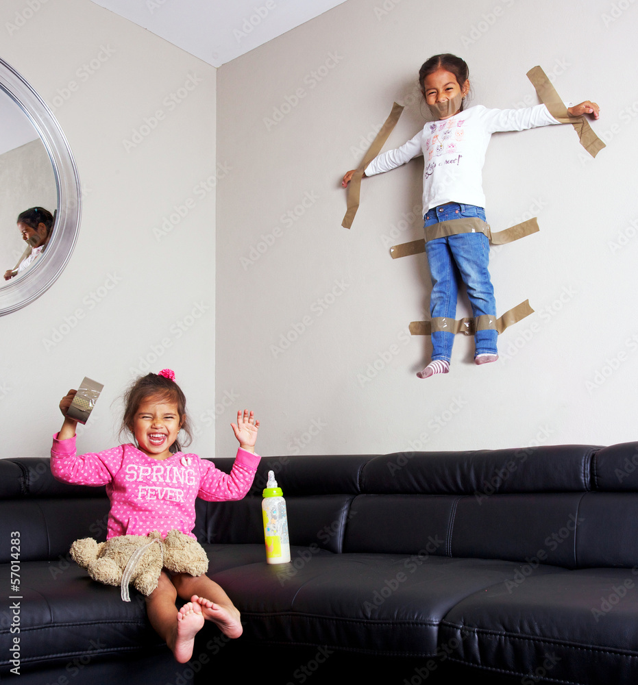 enfant bavard accroché au mur par sa soeur Stock Photo