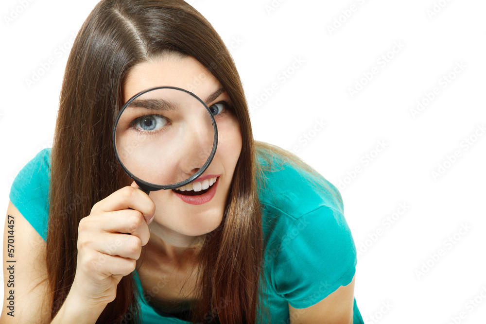 Attractive girl looking through a magnifying glass over white Attractive girl looking through a magnifying glass over white