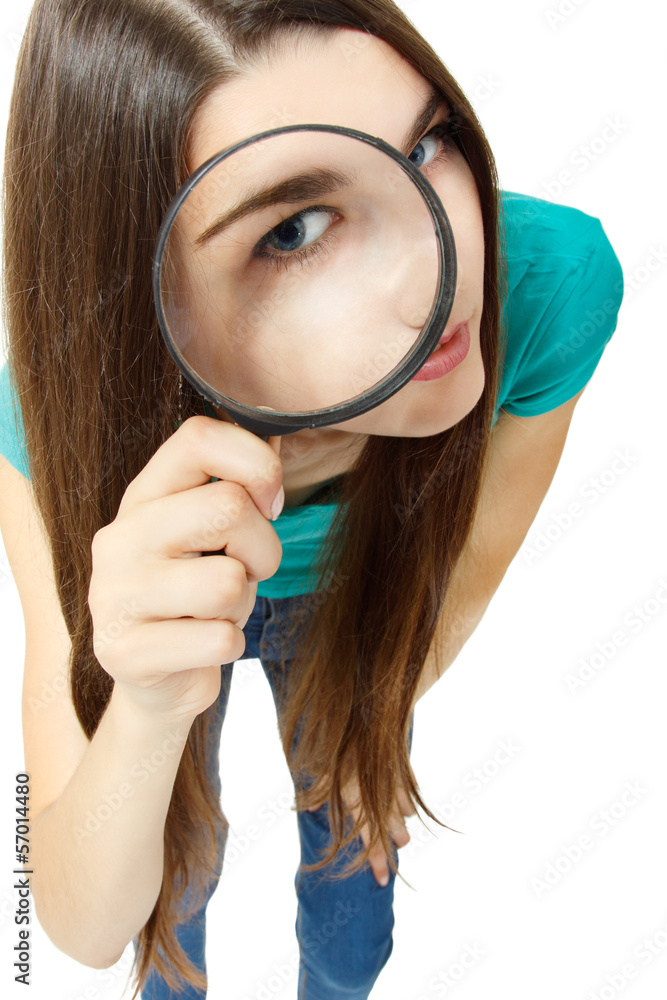 Attractive girl looking through a magnifying glass over white Attractive girl looking through a magnifying glass over white