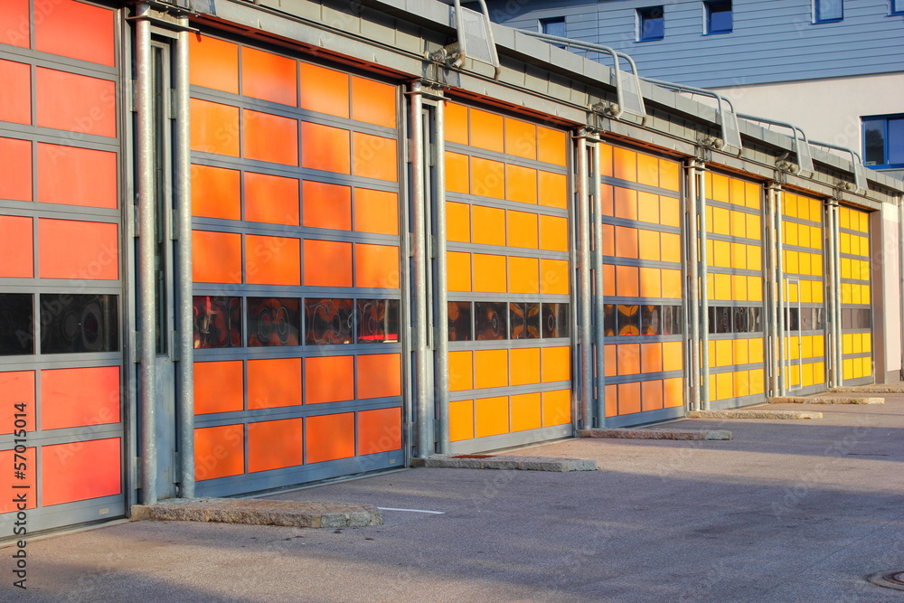 Rote, gelbe und orange Garagentore eines Feuerwehrhauses
