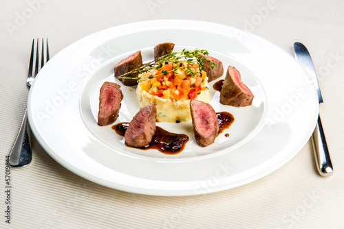 Beef and mashed potatoes decorated with vegetables