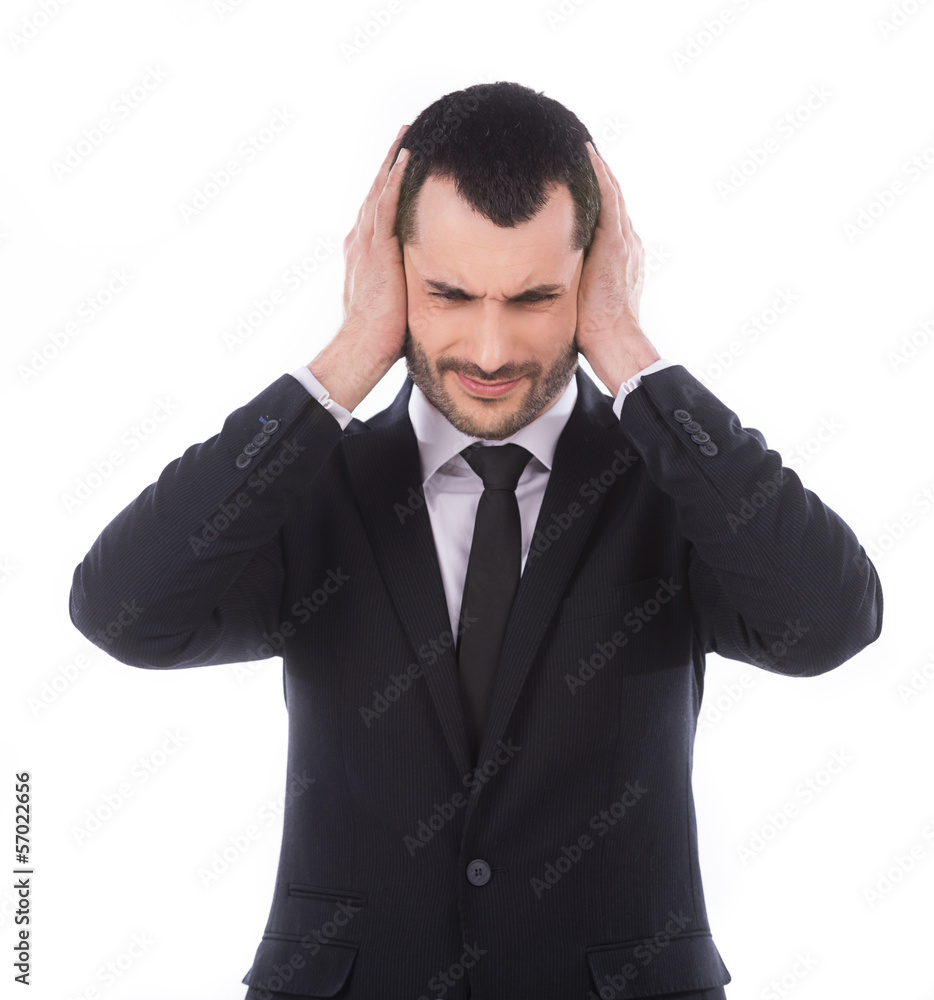 Annoyed businessman covering his ears with his hands Annoyed businessman covering his ears with his hands
