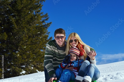 family having fun on fresh snow at winter
