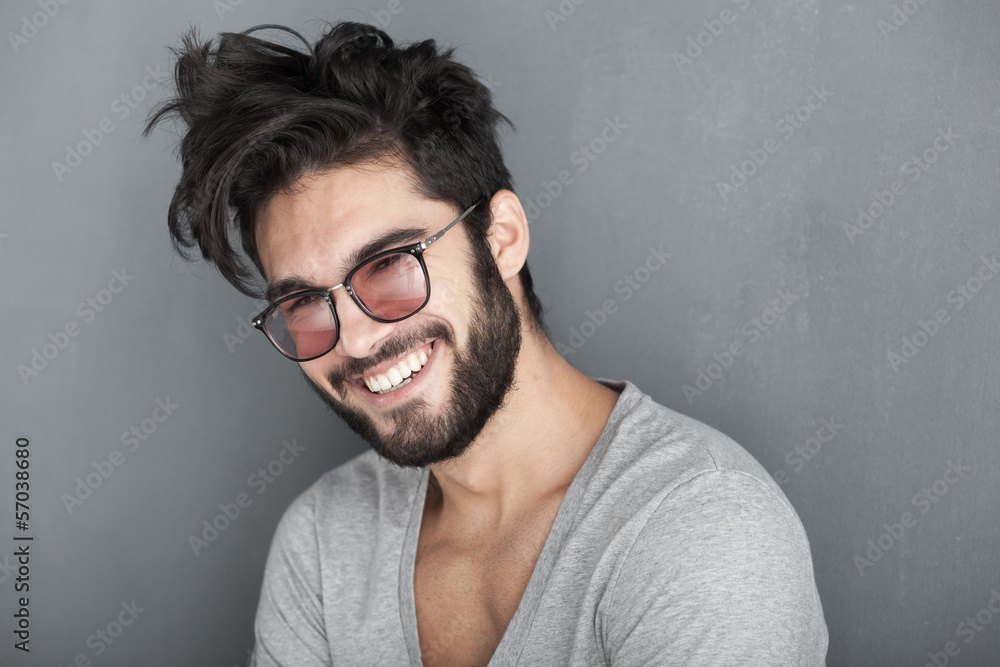 sexy man with beard smiling big against wall - obrazy, fototapety, plakaty 