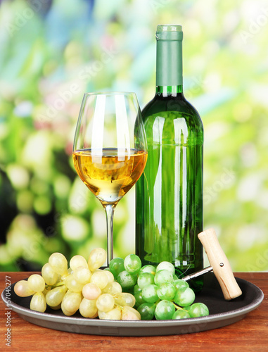 Wine bottle and glass of wine on tray  on bright background