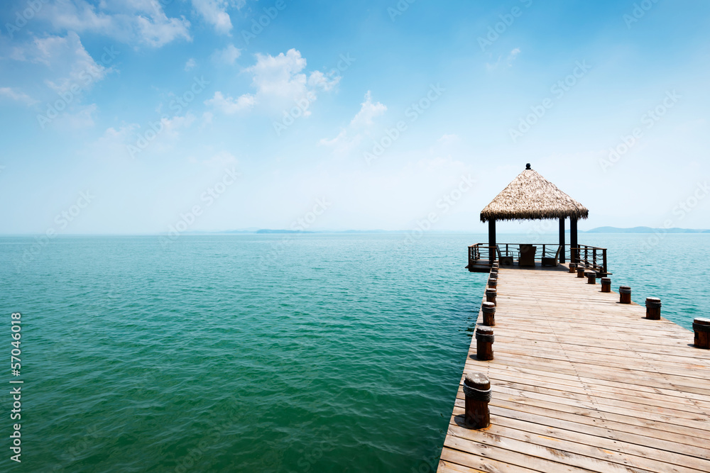 Wooden jetty over the beautiful Maldivian sea with blue sky Wooden jetty over the beautiful Maldivian sea with blue sky