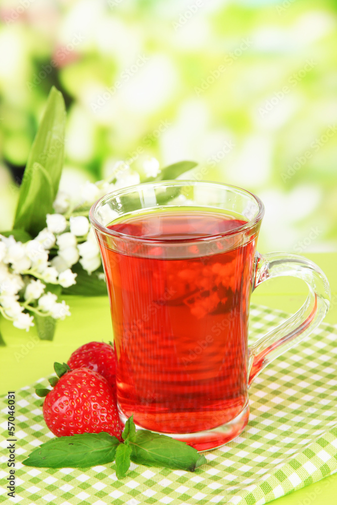 Delicious strawberry tea on table on bright background Delicious strawberry tea on table on bright background