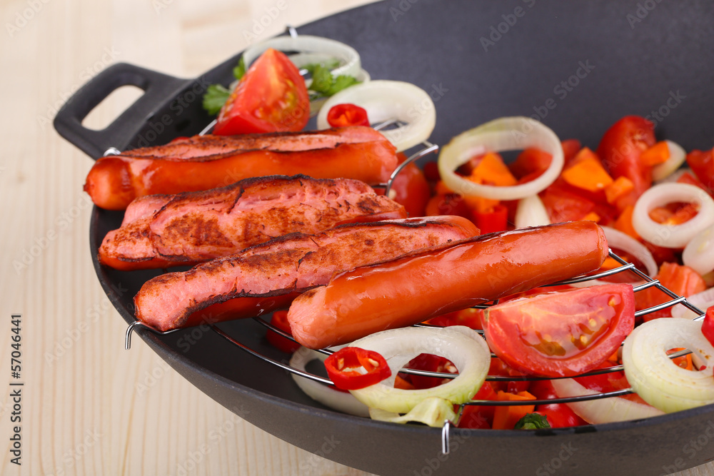 Delicious sausages with vegetables in wok Delicious sausages with vegetables in wok