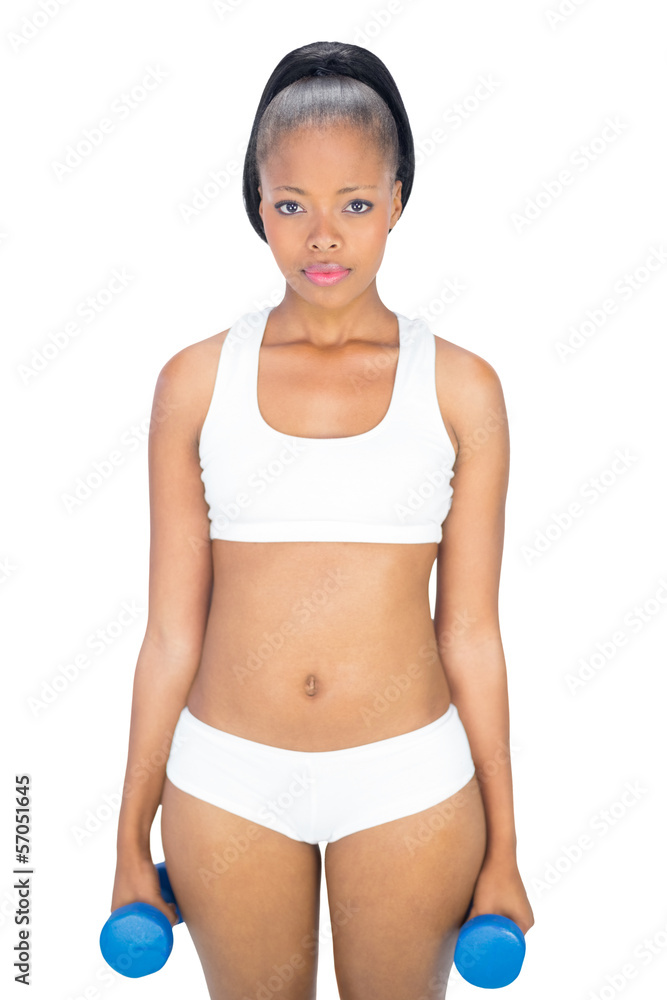 Serious woman in sportswear holding blue dumbbells Serious woman in sportswear holding blue dumbbells