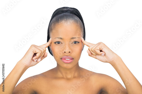 Attractive woman pointing to her head and looking at camera