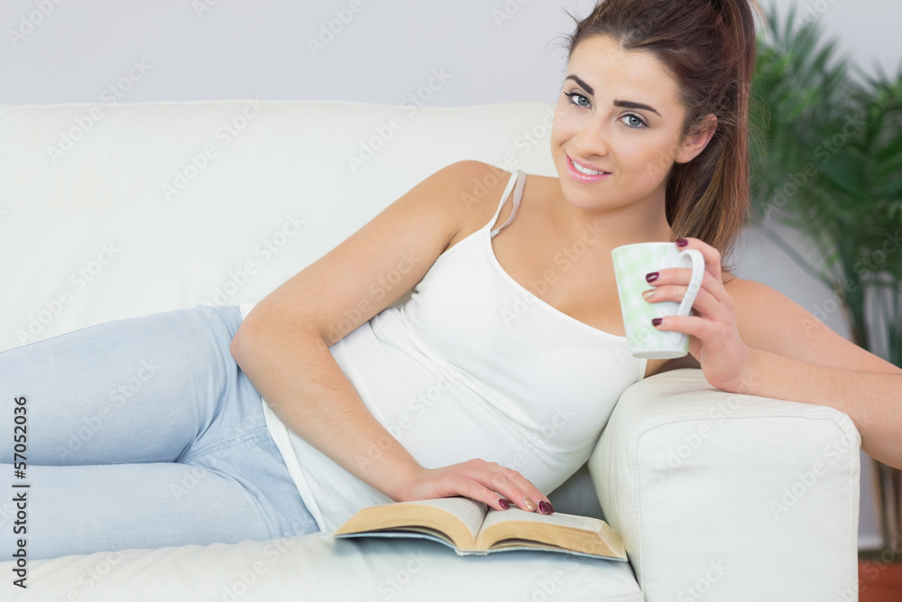 Smiling woman reading a book and having coffee Smiling woman reading a book and having coffee