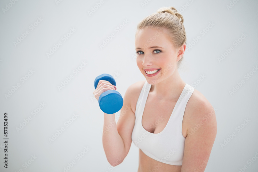 Smiling sporty blonde holding dumbbell Smiling sporty blonde holding dumbbell