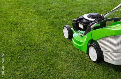 Green lawnmower on green lawn photo