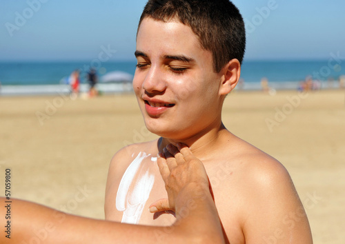 Sunscreen at the beach, teen on holiday photo