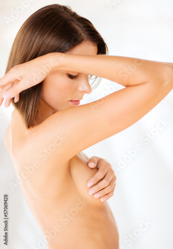 woman checking breast for signs of cancer