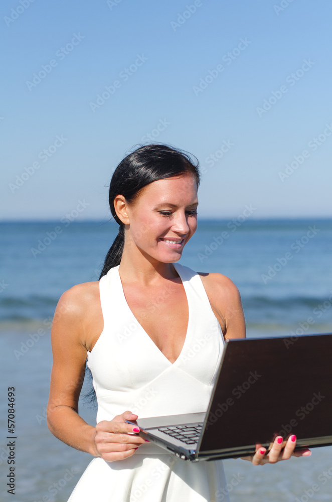Attractive woman with notebook on the beach. Place for text