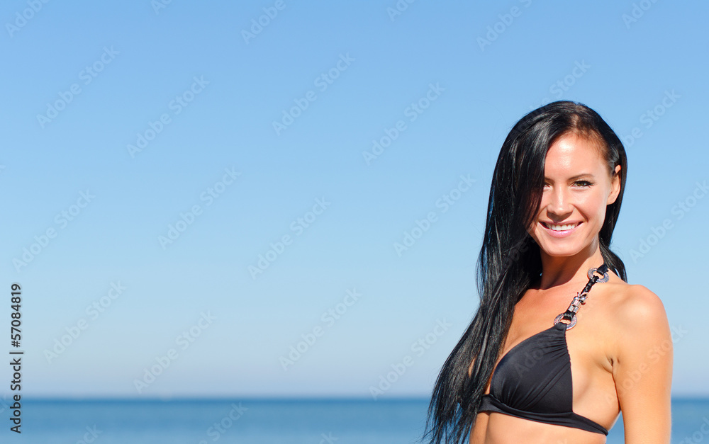Attractive woman posing over blue sea. Place for text.