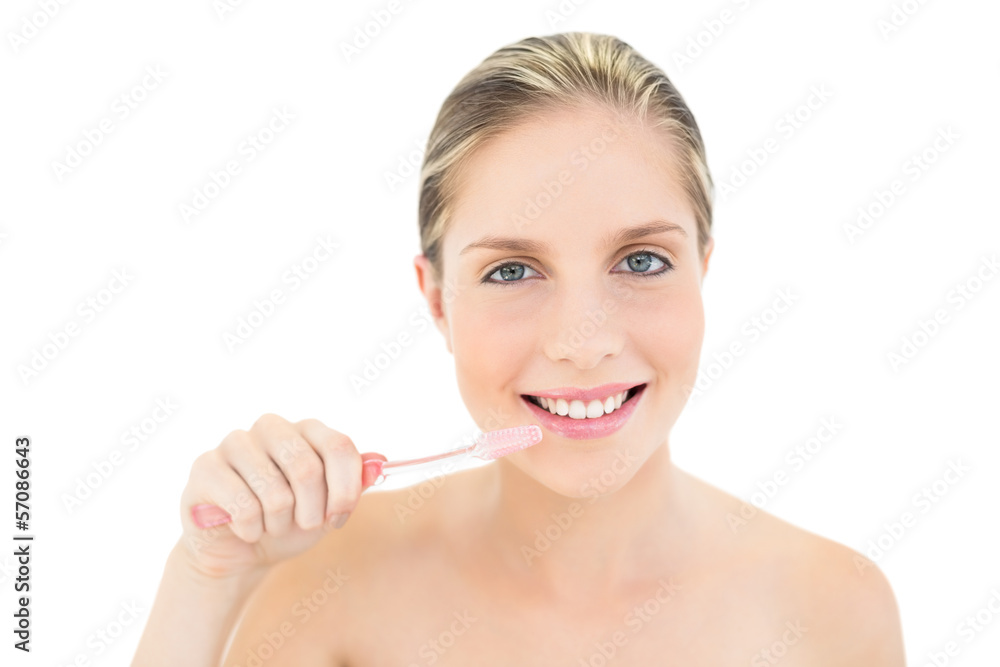 Amused fresh blonde woman brushing her teeth Amused fresh blonde woman brushing her teeth