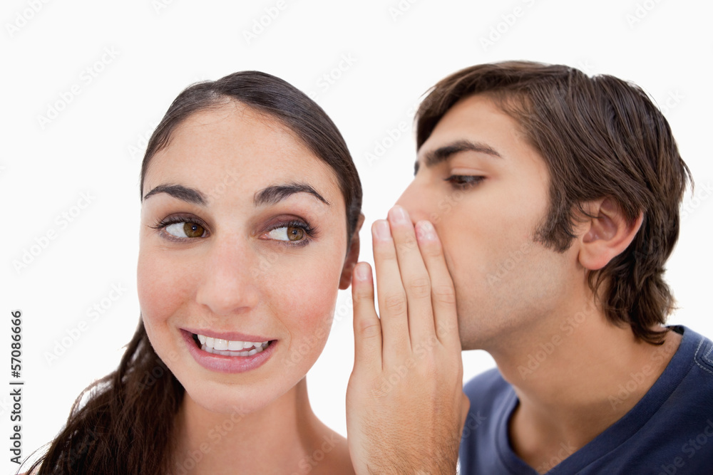 Man whispering something to his fiance Man whispering something to his fiance