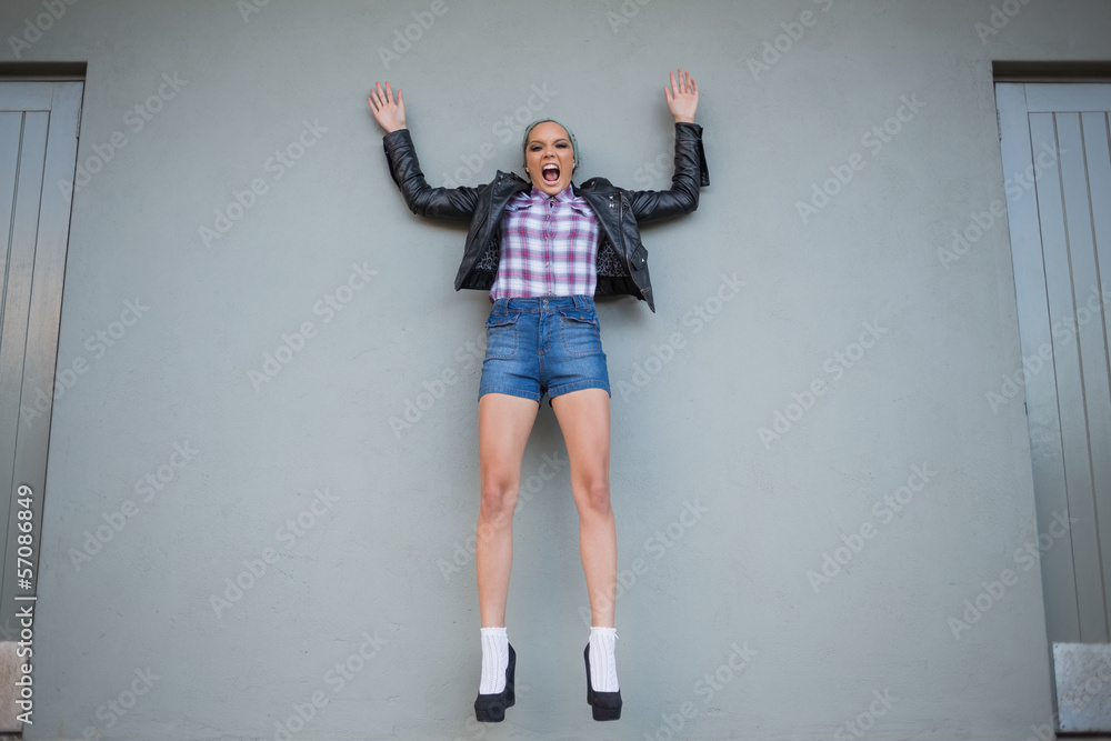 Attractive woman jumping and screaming while looking at camera Attractive woman jumping and screaming while looking at camera
