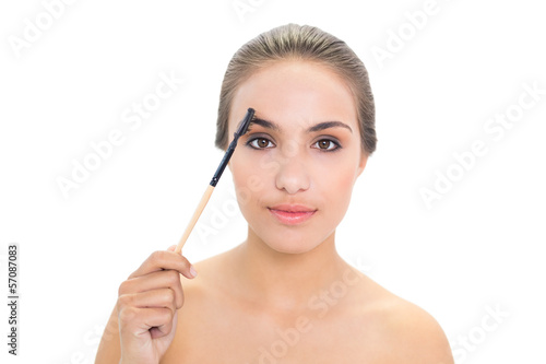 Content brunette woman using eyebrow brush