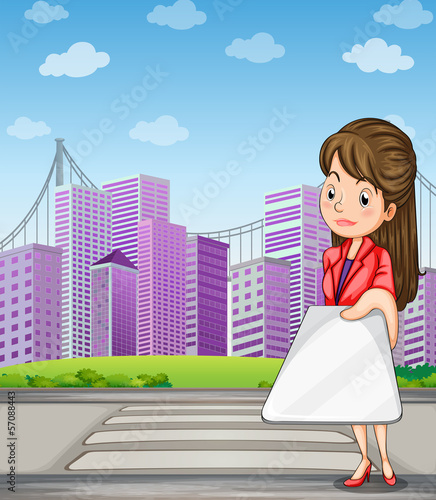 A woman in front of the tall buildings holding a gadget