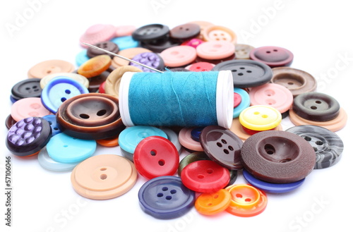 Blue thread with needle and collection of colored sewing buttons