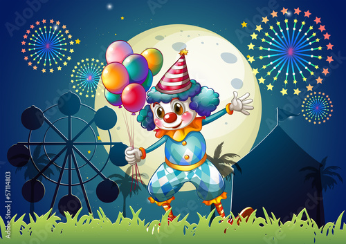 A clown with balloons standing in front of the carnival