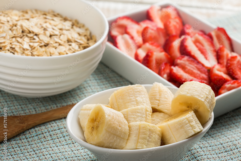 Banana, strawberries, oat flakes in bowl Banana, strawberries, oat flakes in bowl